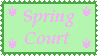 Stamp with dark green border, pastel green background, and pale pink letters reading Spring Court, with small pink flowers at each corner.